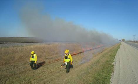 Fire crew members wear heat-resistant clothing, a fire safety shelter, and other personal protective equipment. But their first line of safety lies in a working knowledge of fire behavior and in maintaining effective communication--the black pouches on their fronts keep their hand-held radios readily accessible.