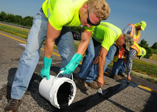 Workers installing continuous count sensors on a highway